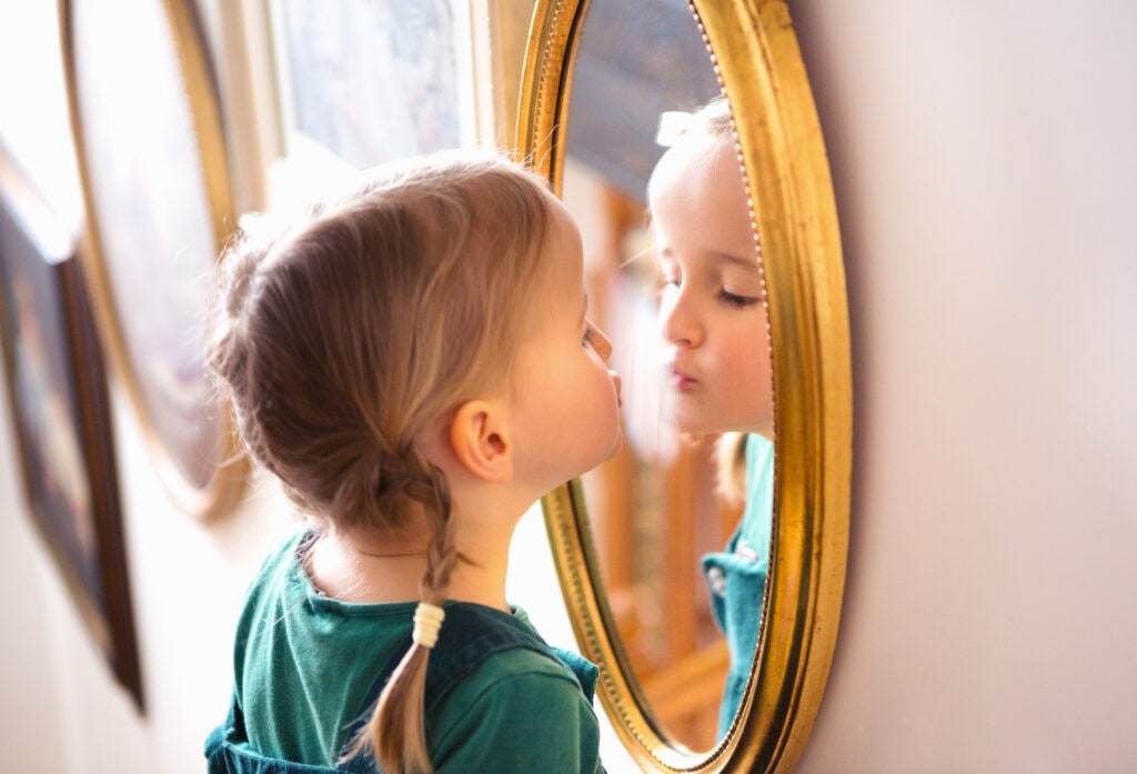 Young girl looking in the mirror