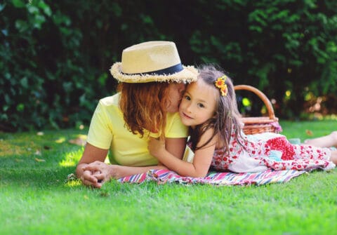 Mother and daughter lying on blanket