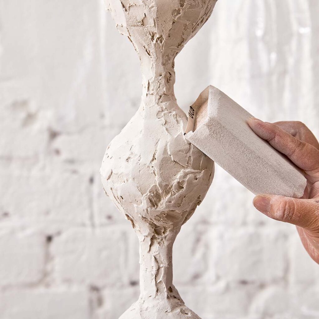 Sanding the plaster on the funnels on the lamp