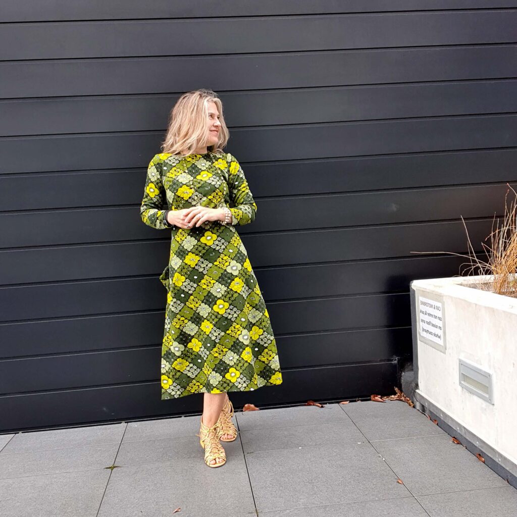 Stephanie King wearing a green and yellow printed dress