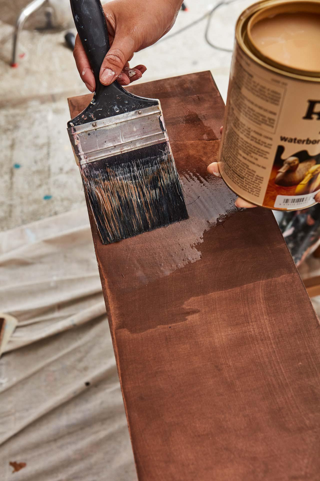 Plank of stained wood being painted with Resene Aquaclear varnish