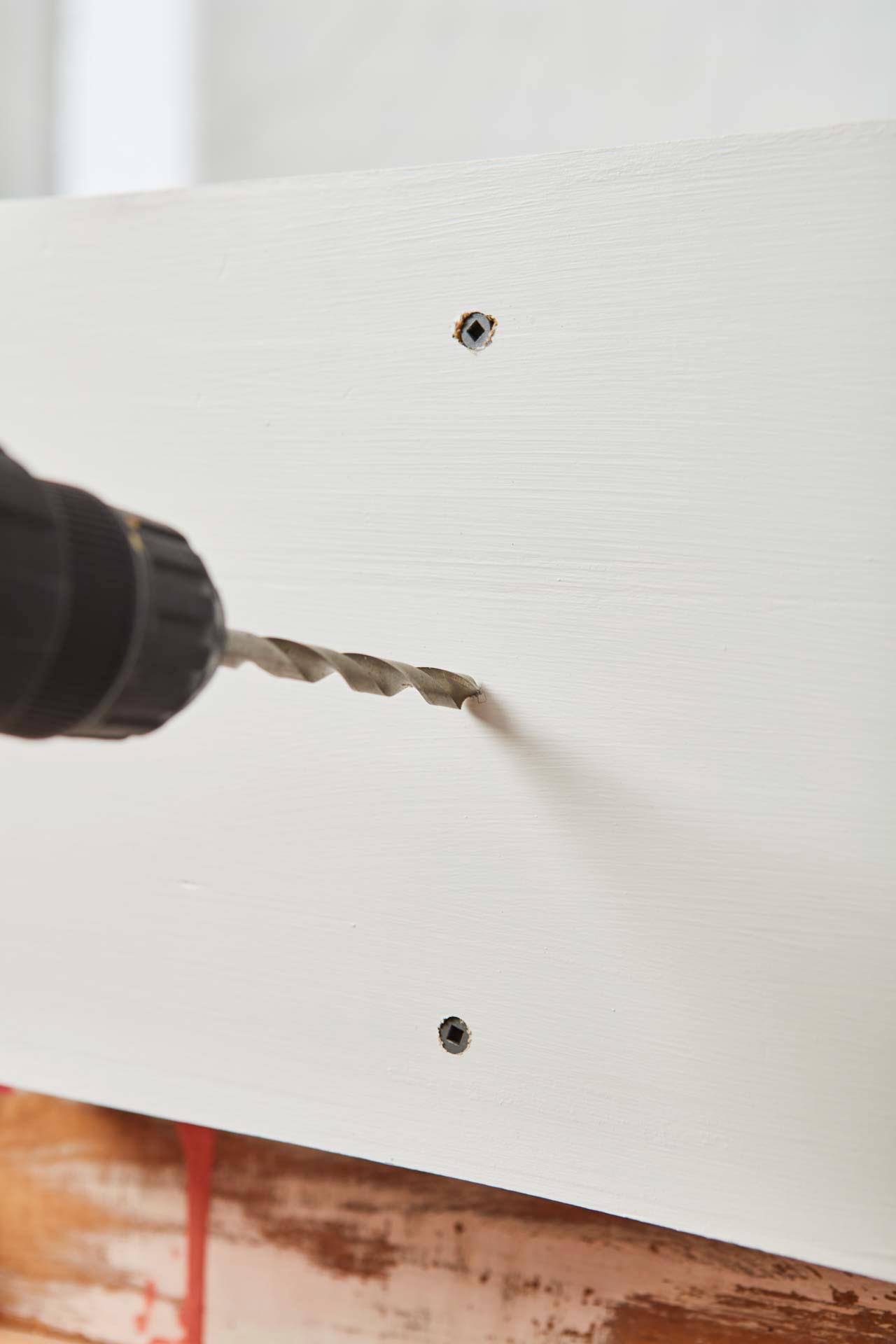 Power drill about to drill a hole between two holes