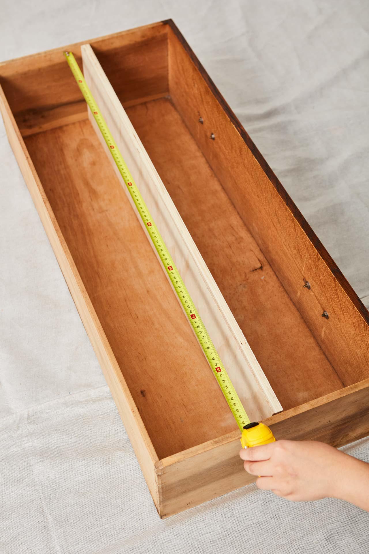 Vintage drawer being measured by yellow measuring tape