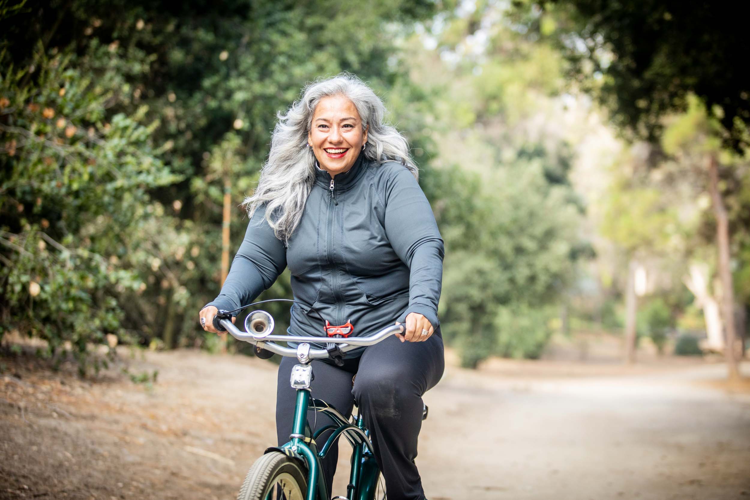 grey haired woman riding a bike