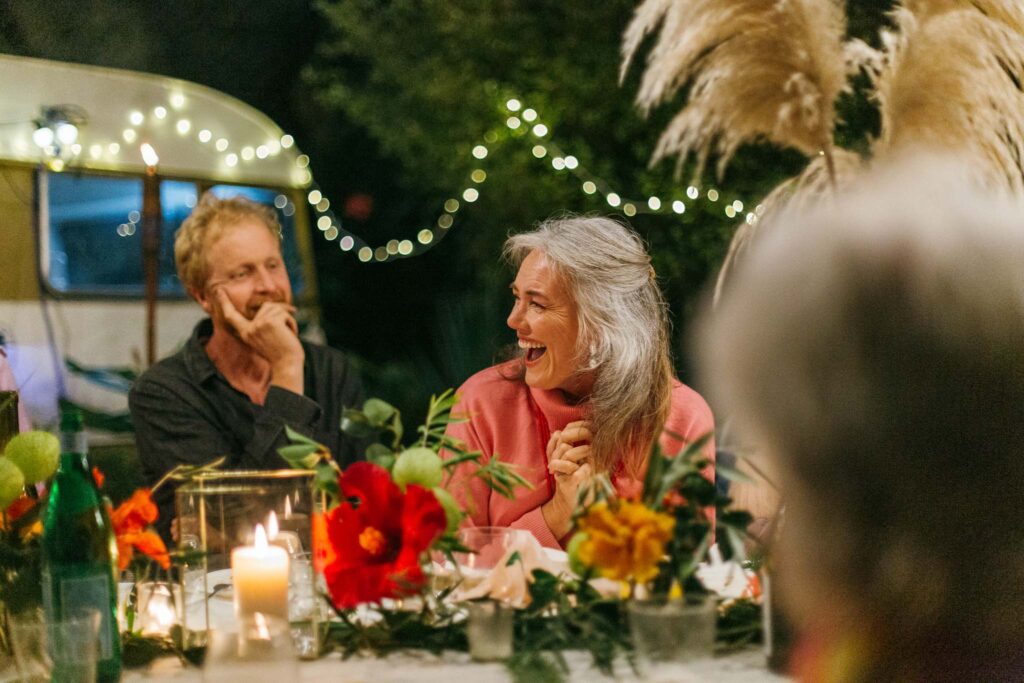 Petra Bagust and husband smiling at outdoor dinner table