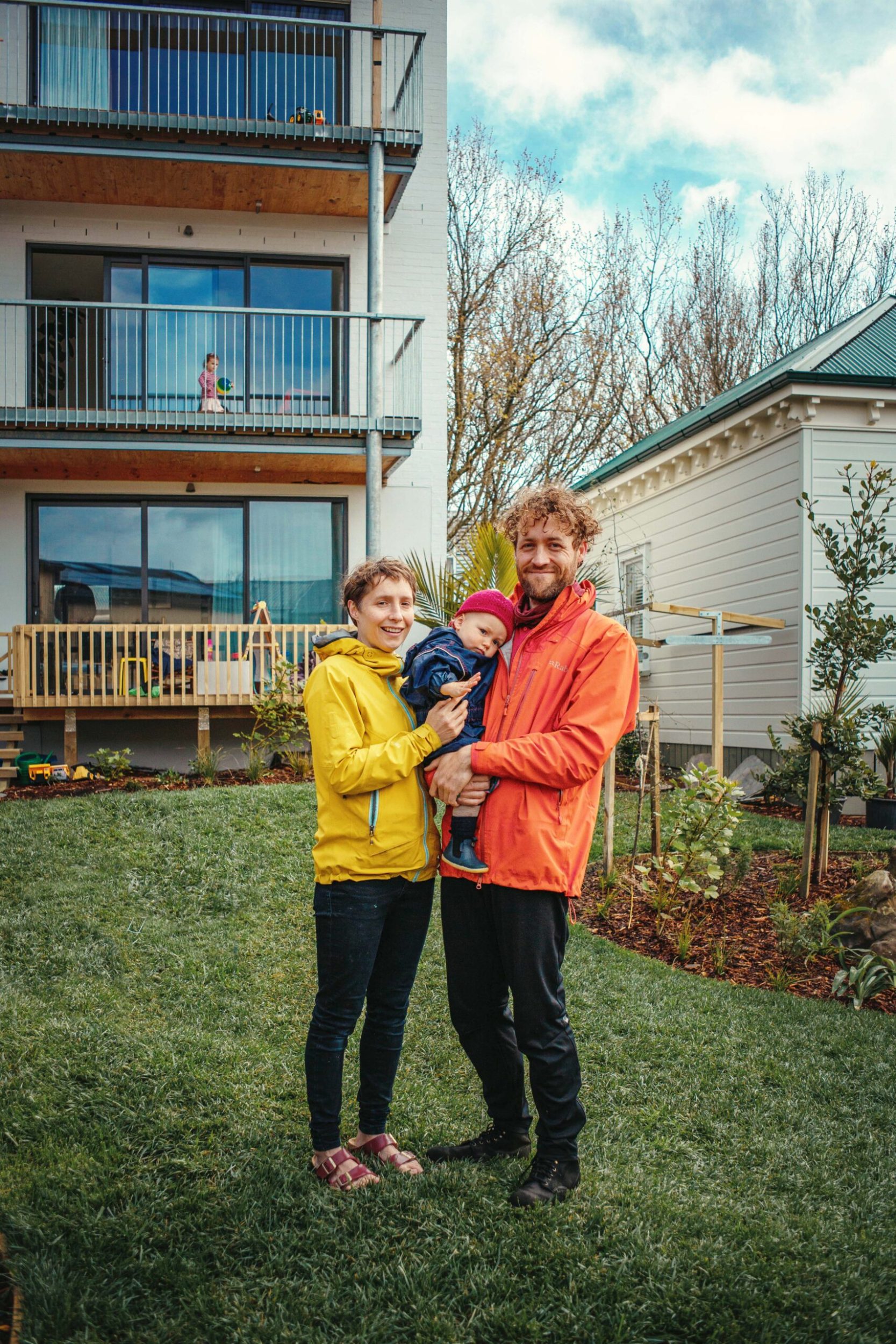 a young family standing in front of a housing building