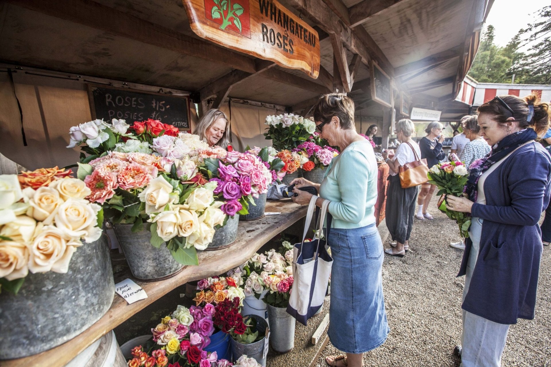 women looking at flowers at a farmers market