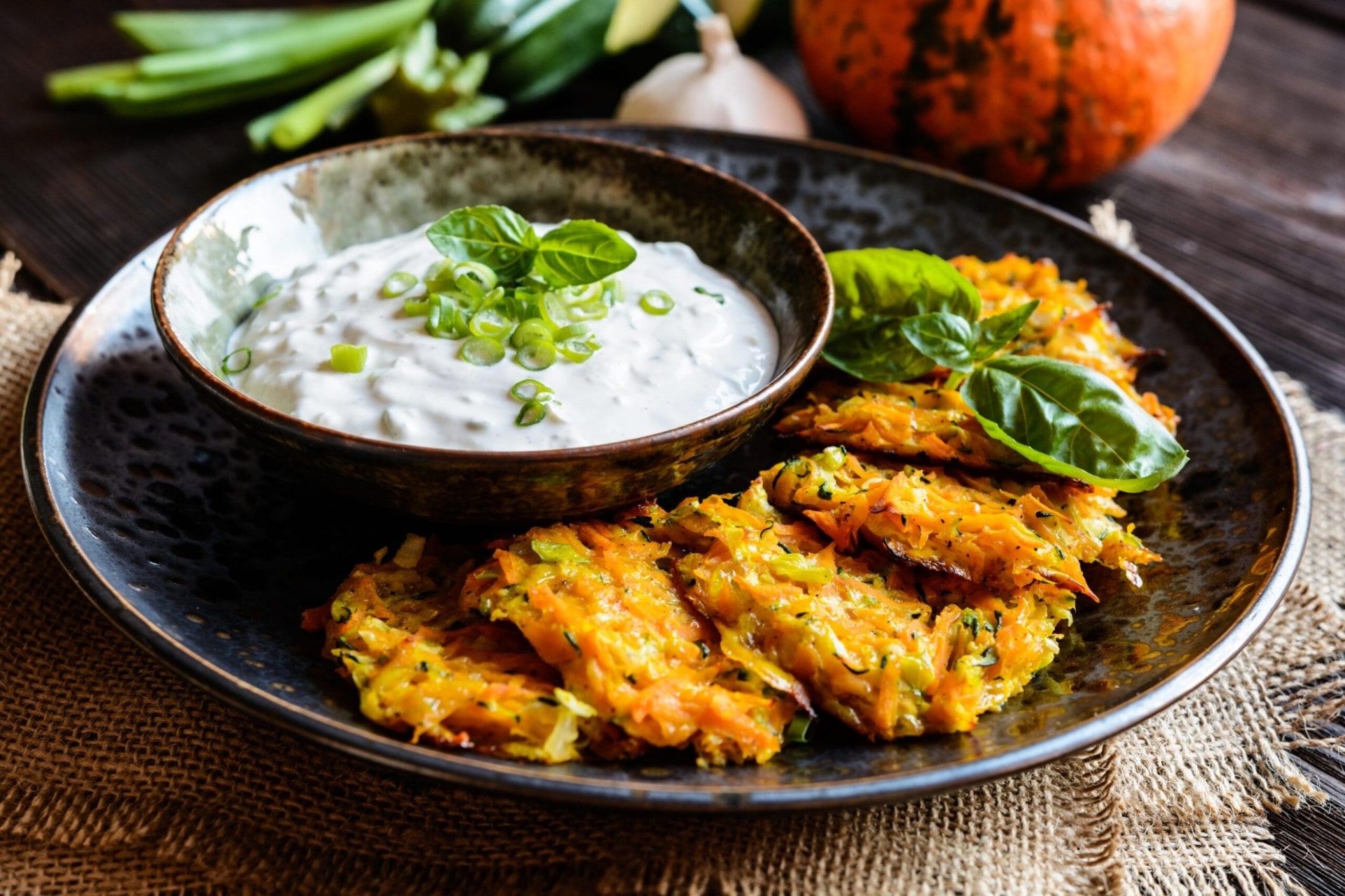 vegetable fritters on a plate with yoghurt dipping sauce