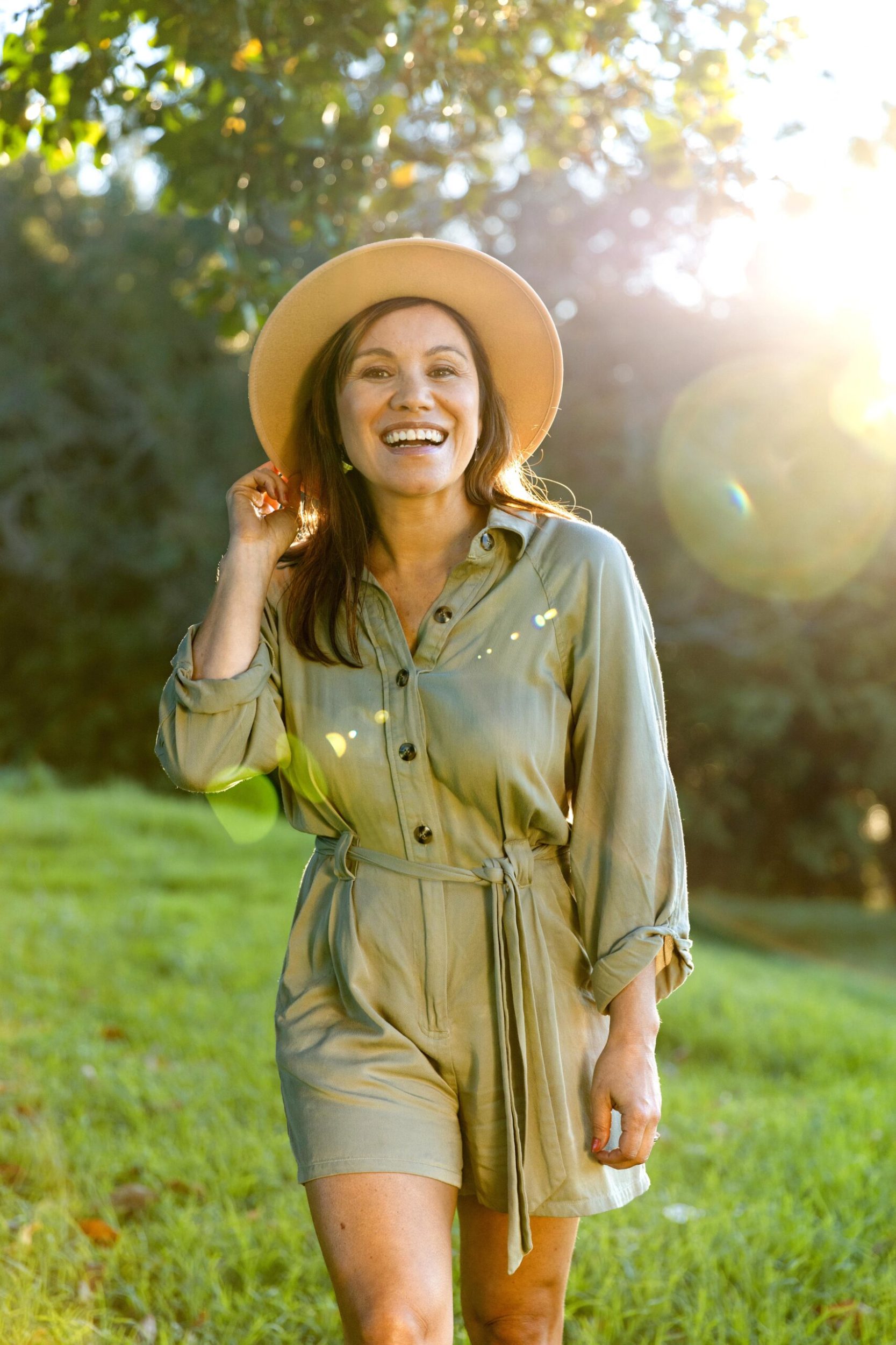 Stacey Morrison wearing a wide-brimmed hat posing in a field