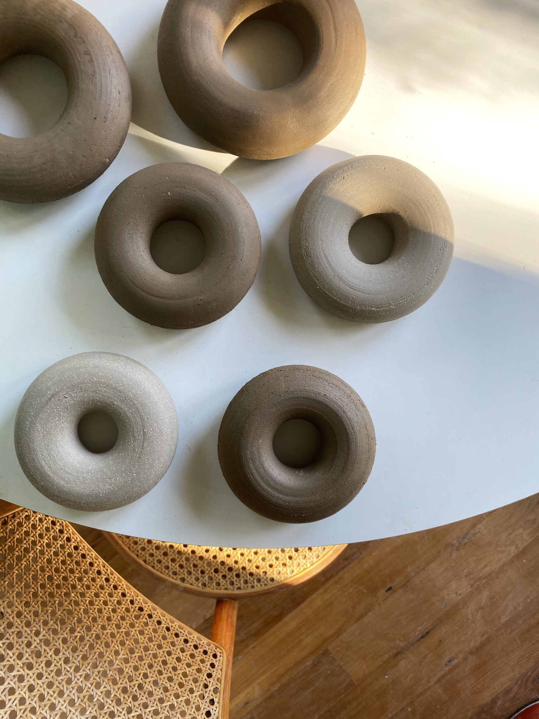 Brown and grey hoop vases laying on a round white table 