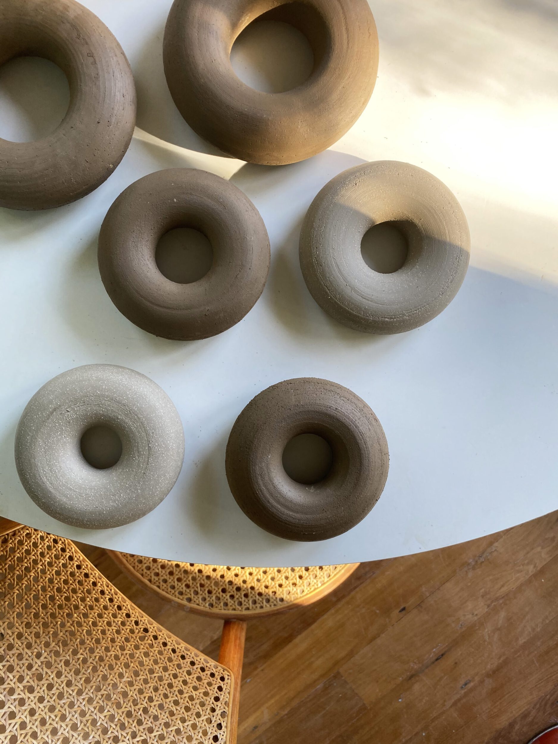 Brown and grey hoop vases laying on a round white table