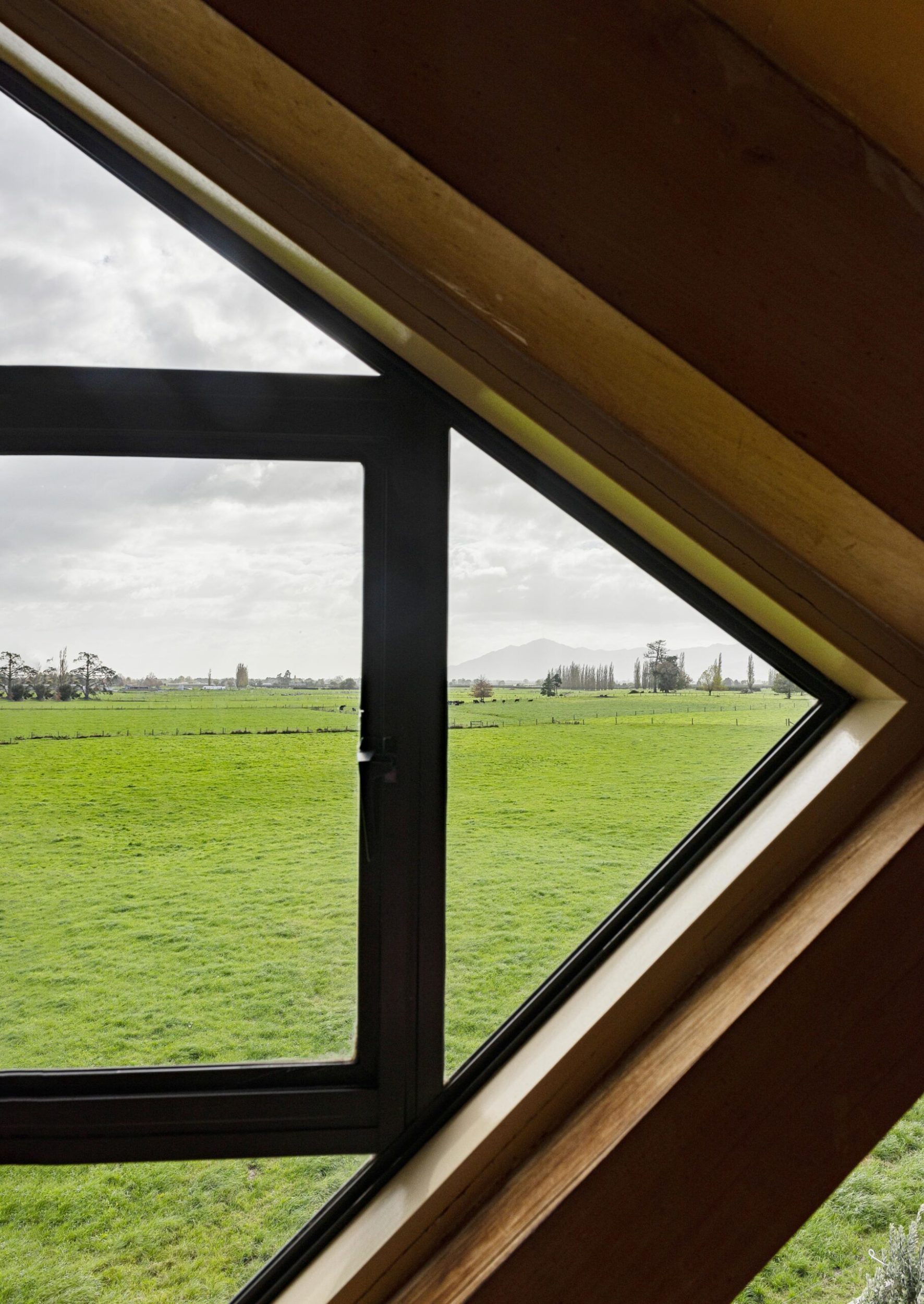 A triangular window facing farmland