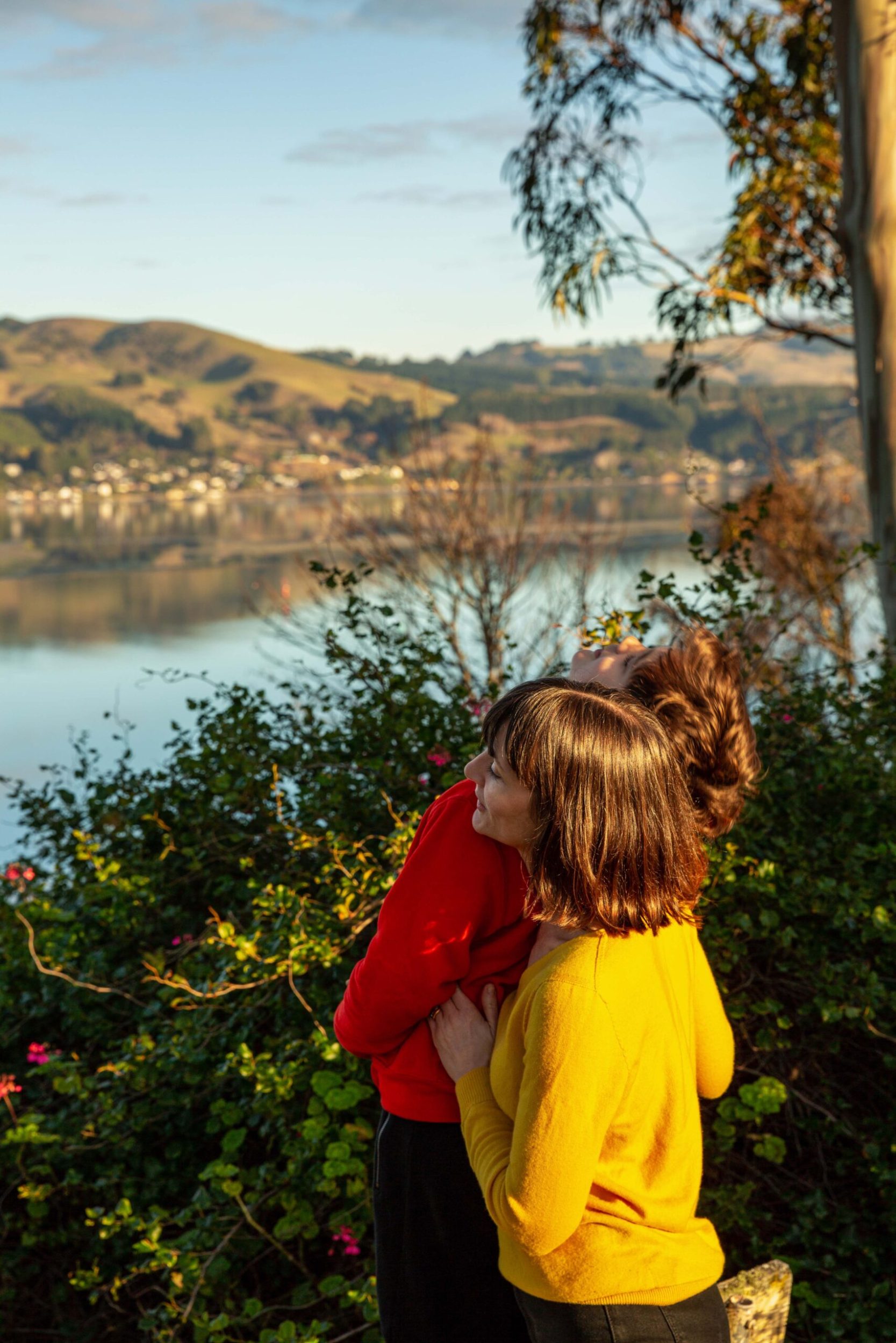 Octavia Cook holding her son Rex while overlooking a lake in Port Chalmers