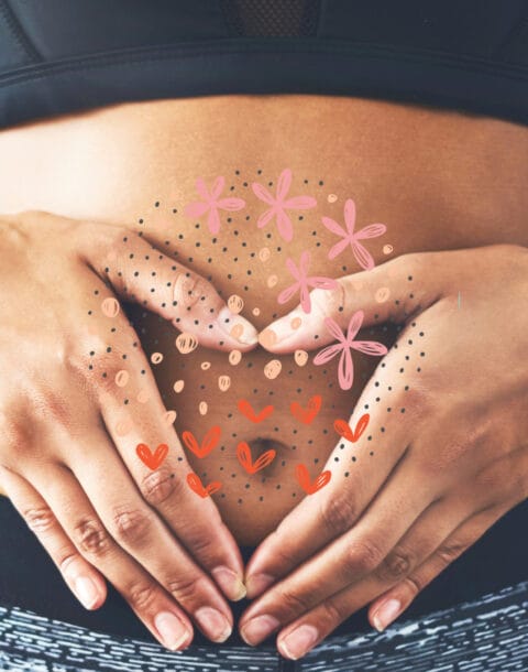 Close up of woman's hands holding stomach with drawings of hearts and flowers