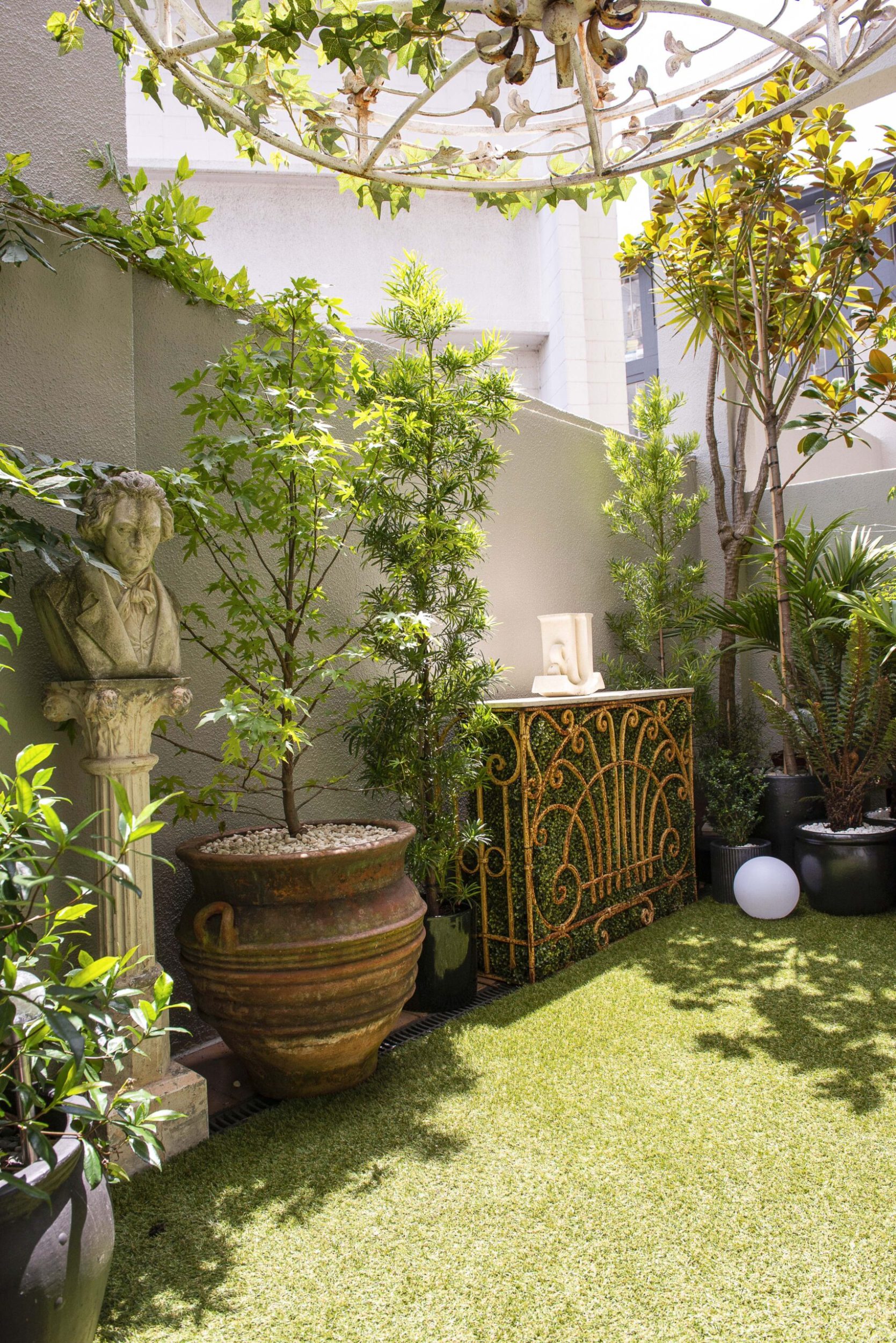 Apartment patio garden with pot plants and faux grass