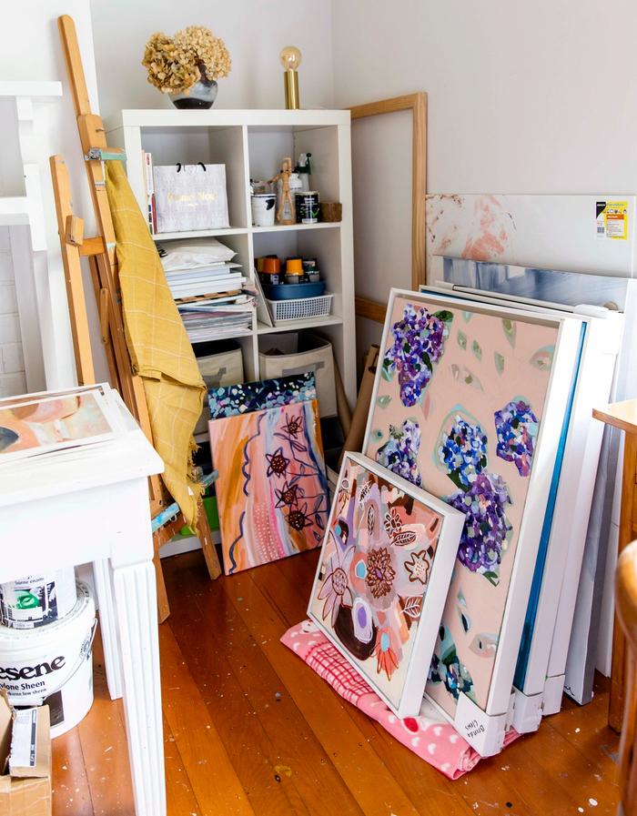 An assortment of artworks by Brenda Clews leaning against wall in art studio