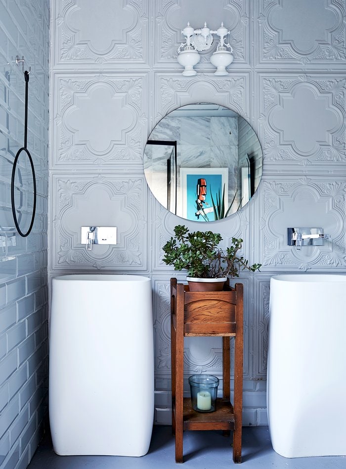 Grey bathroom with round mirror and white large sinks