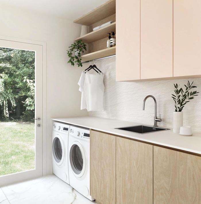 A laundry with built-in cabinetry and a washing machine and dryer.