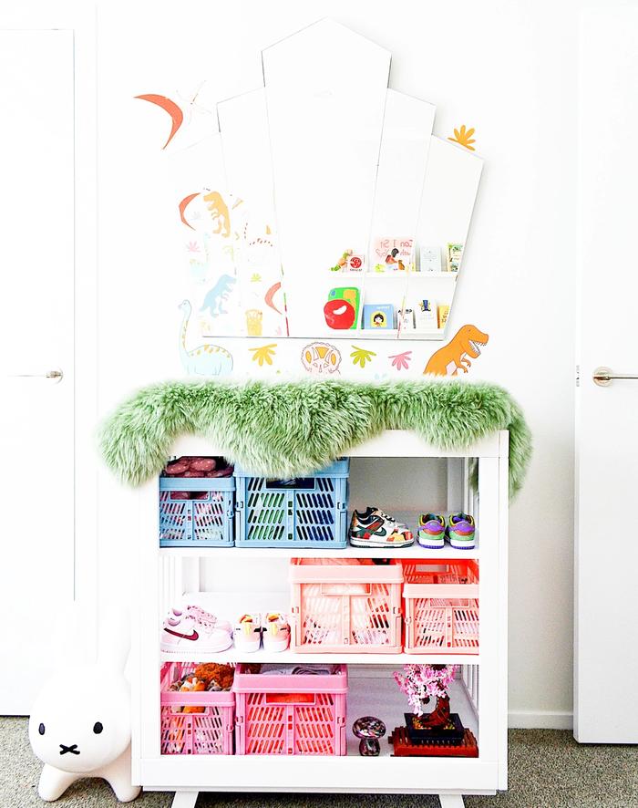 A shelf containing children's toys with a mirror on top.