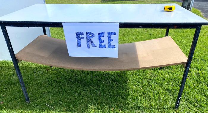 An old table with Free written on a sign stuck to it