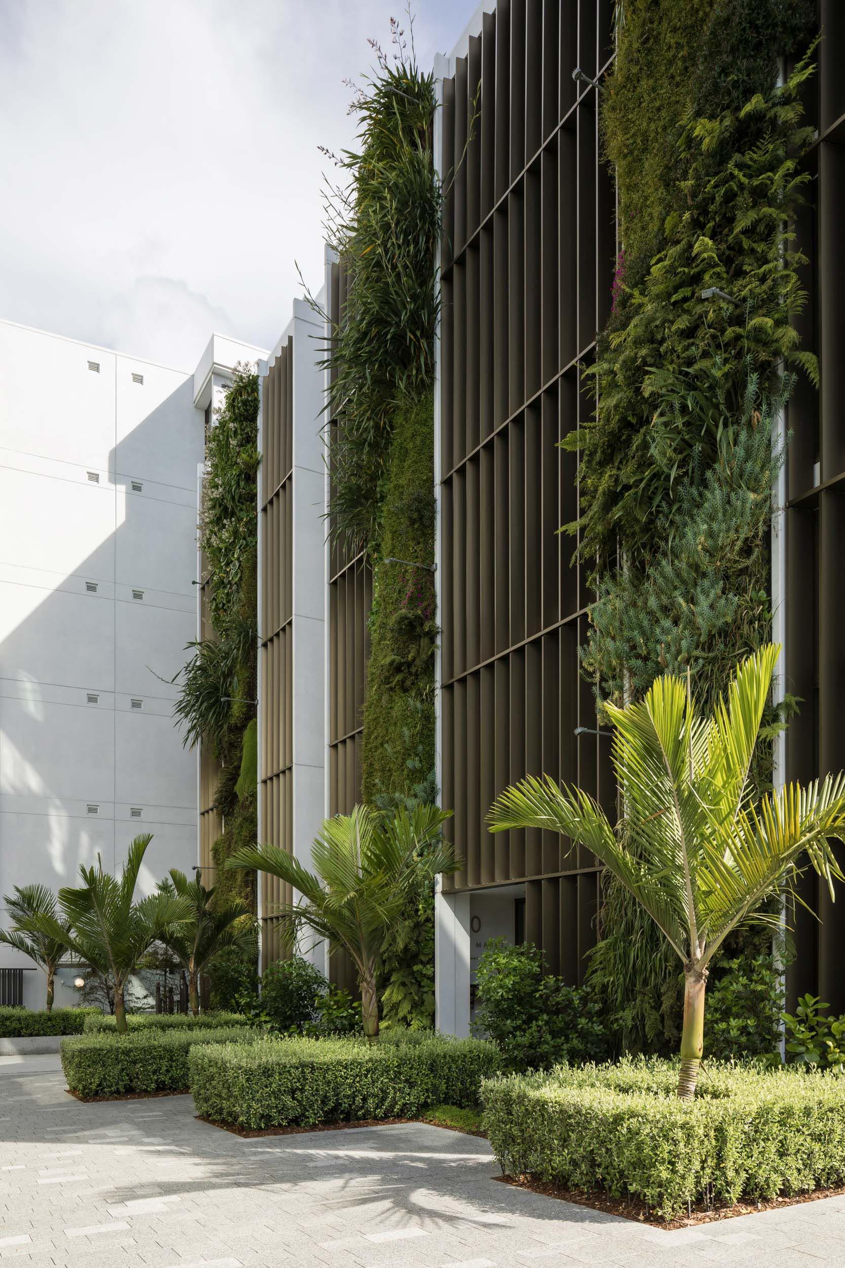 An apartment building with vertical gardens on the side of the building