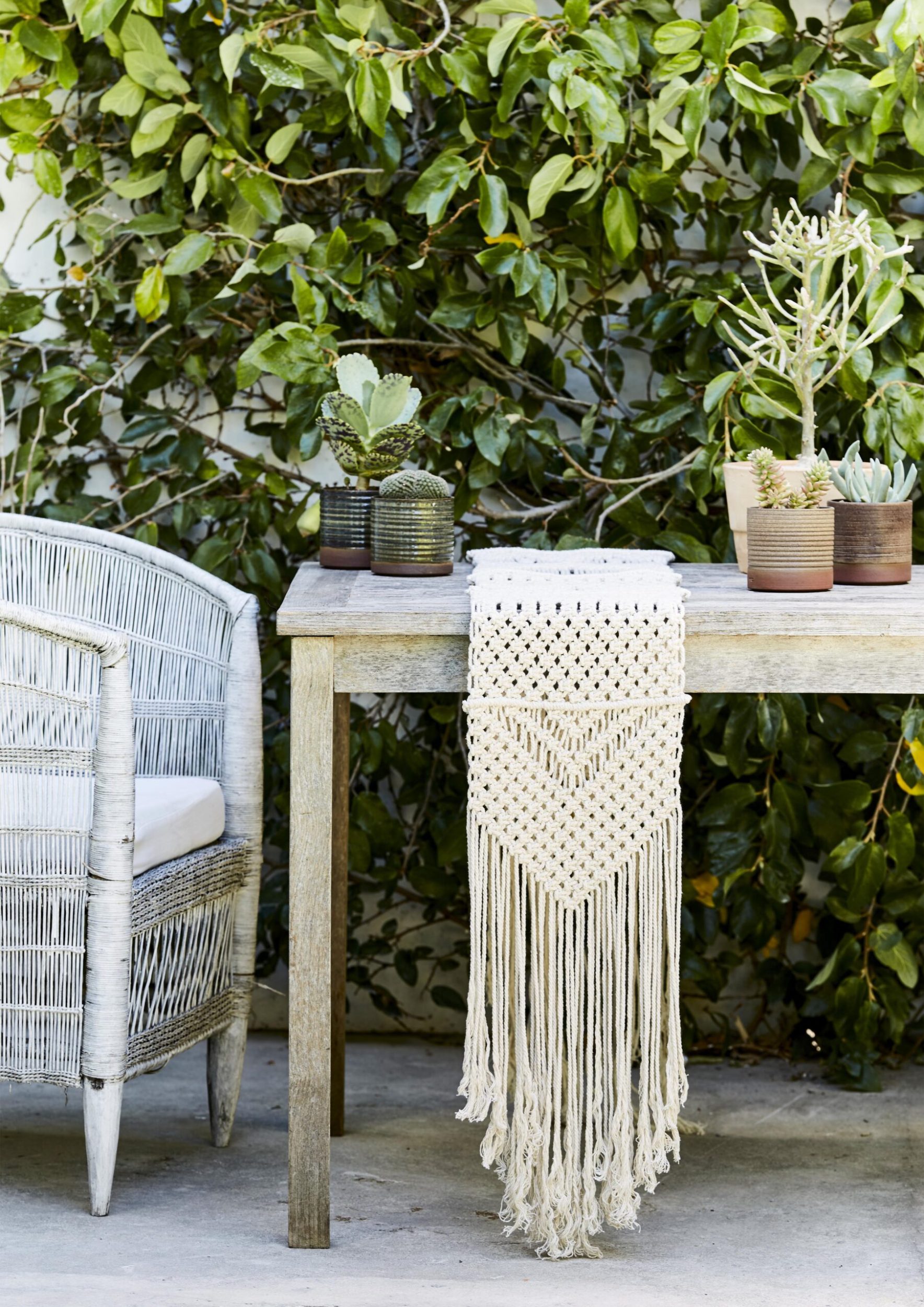 Outdoor table with macramé table runner and cane chair