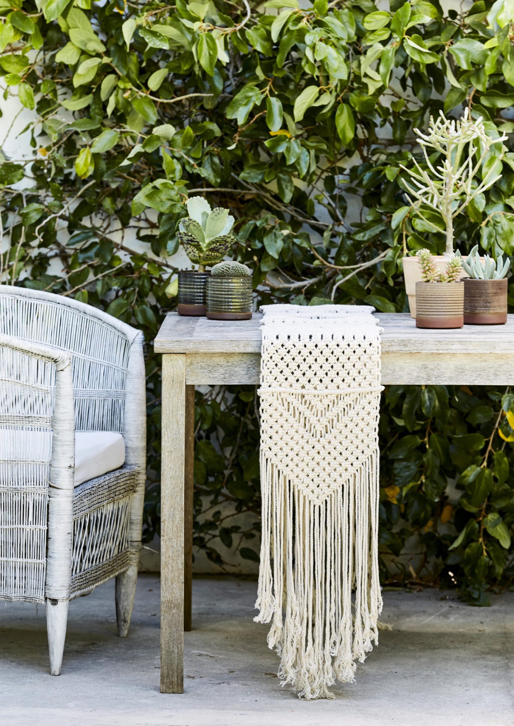 Outdoor table with macramé table runner and cane chair