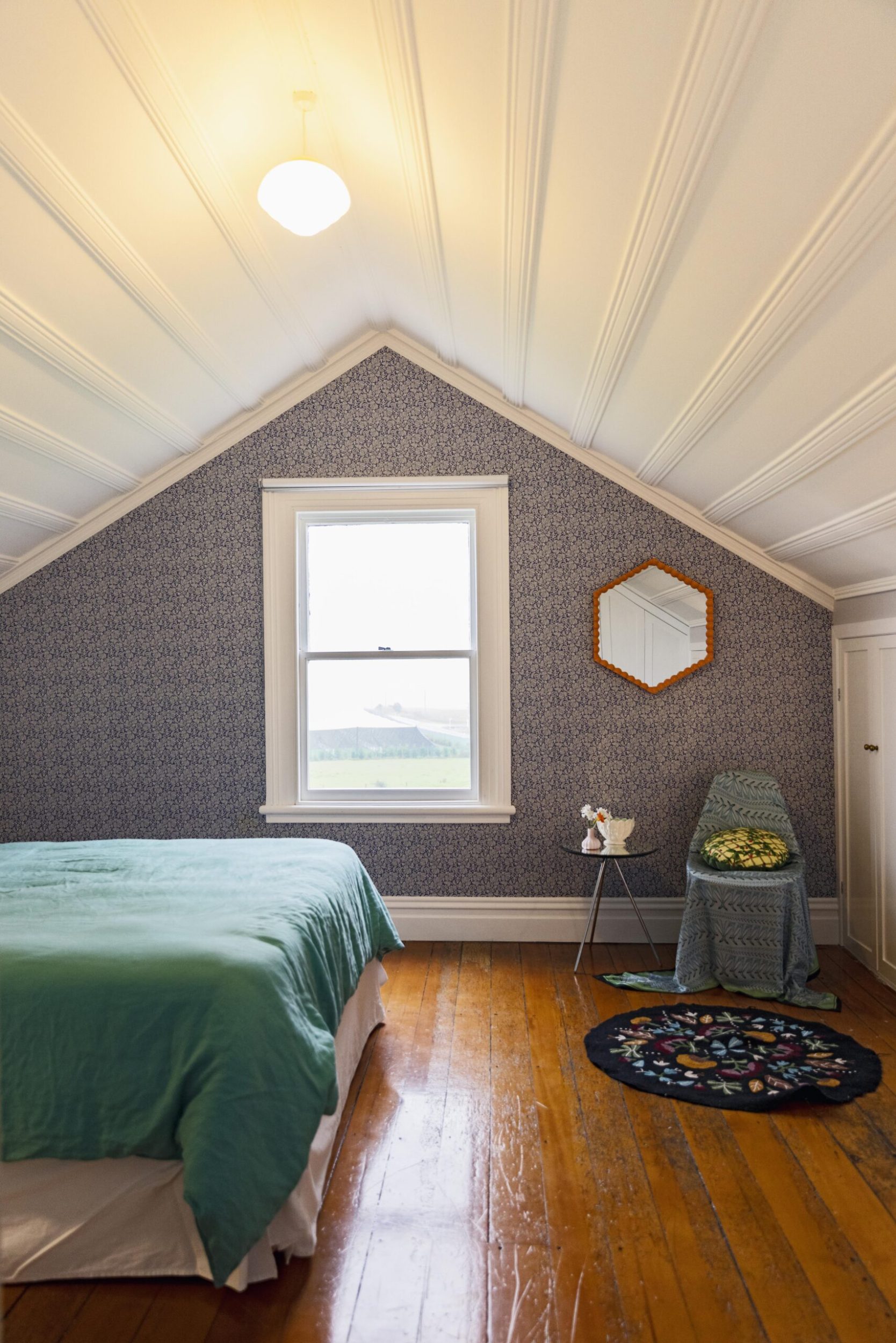 Bedroom with wallpaper and a mirror