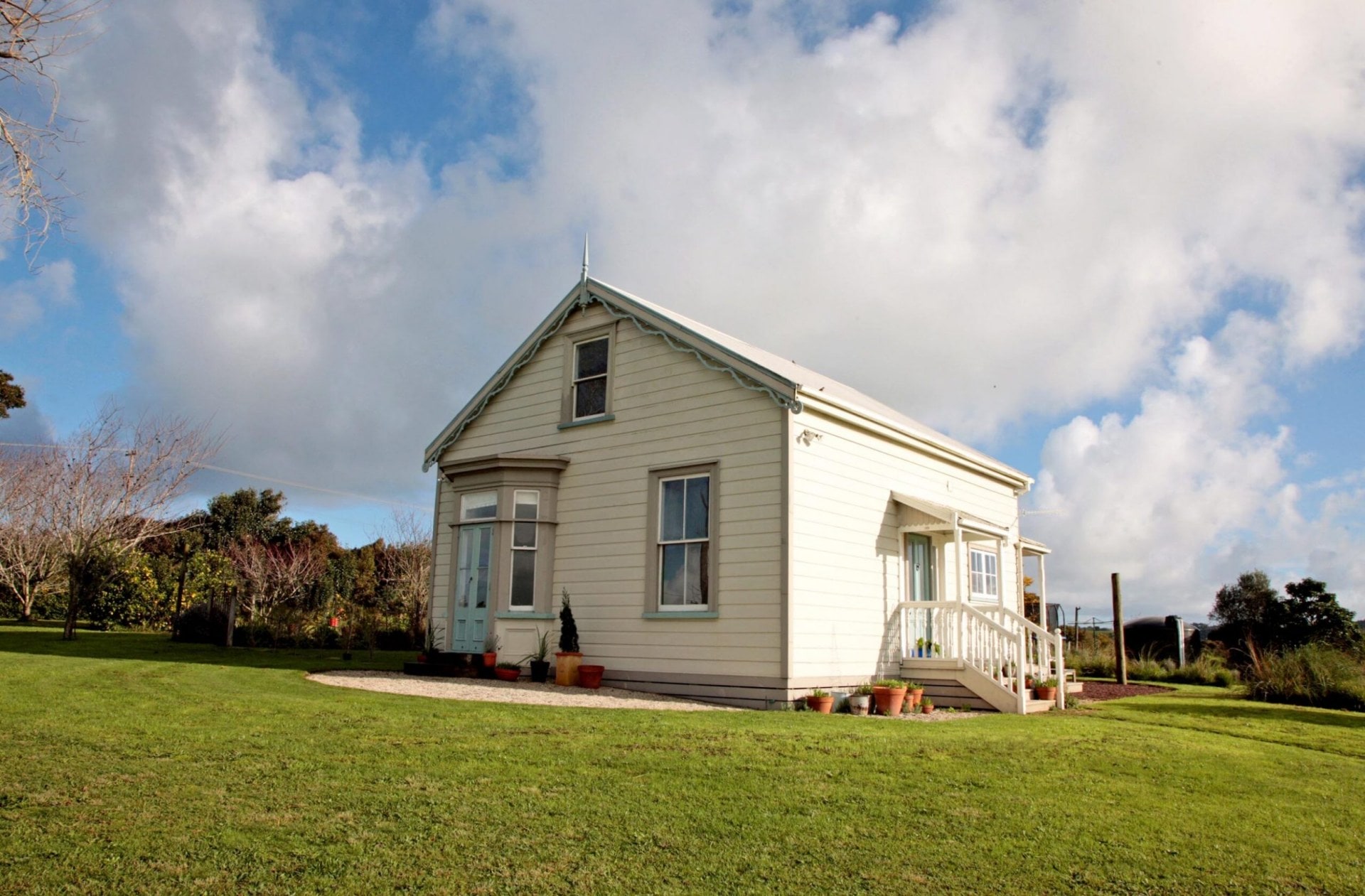 The outside of a white historical house with a gabled roof