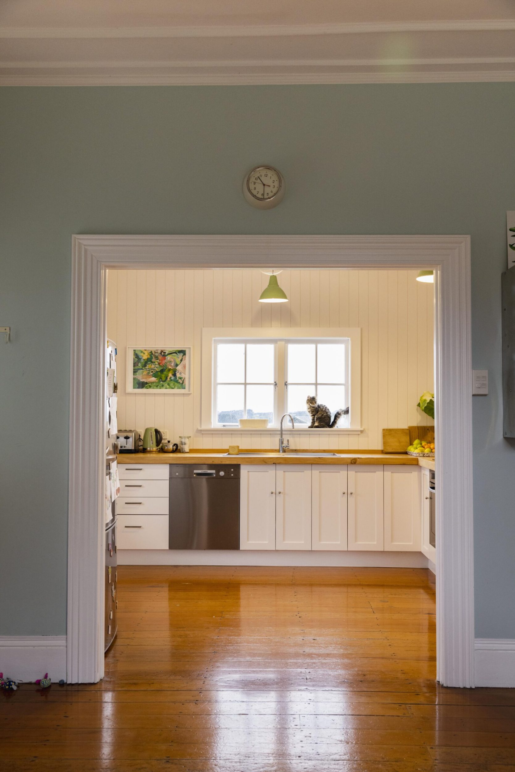 Light green wall frames an open kitchen