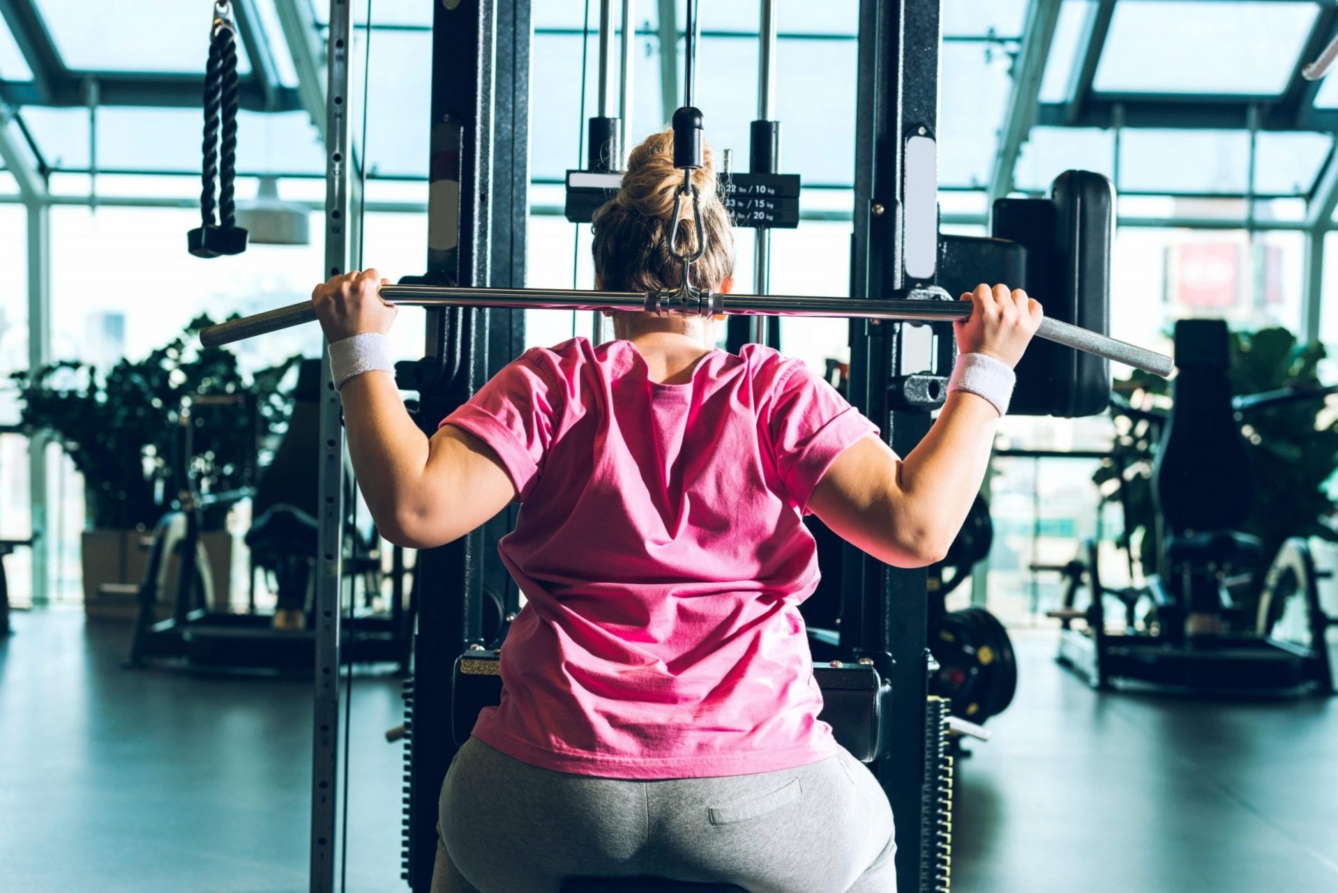 a woman in a pink tshirt on a workout machine