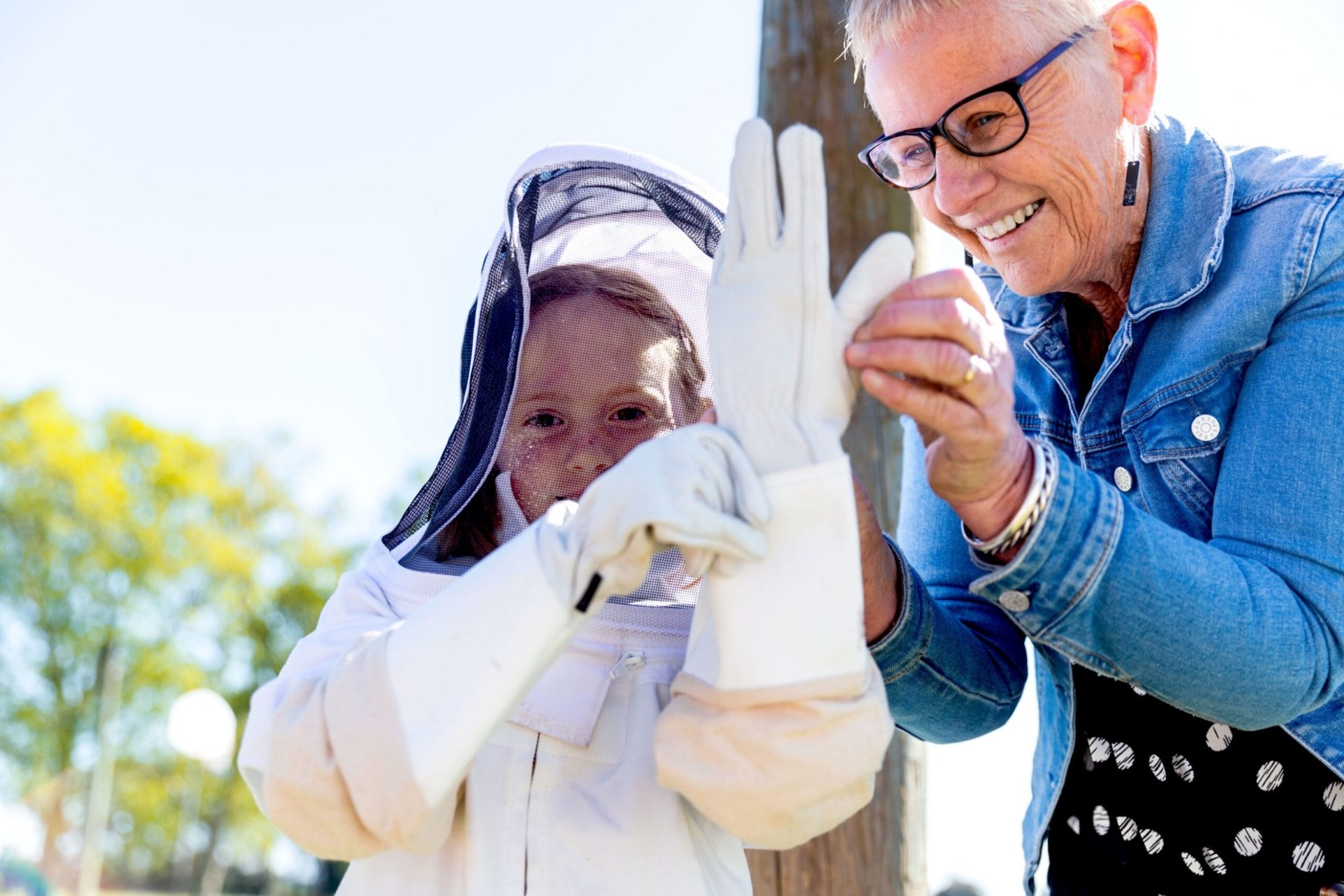 Christine Morrison helping student put on bee suit