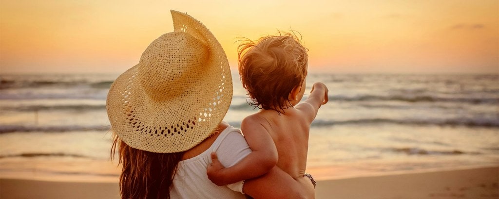 Mother with son enjoying sunset on the beach