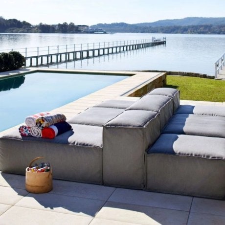 Modular outdoor seating arranged next to an outdoor pool. 