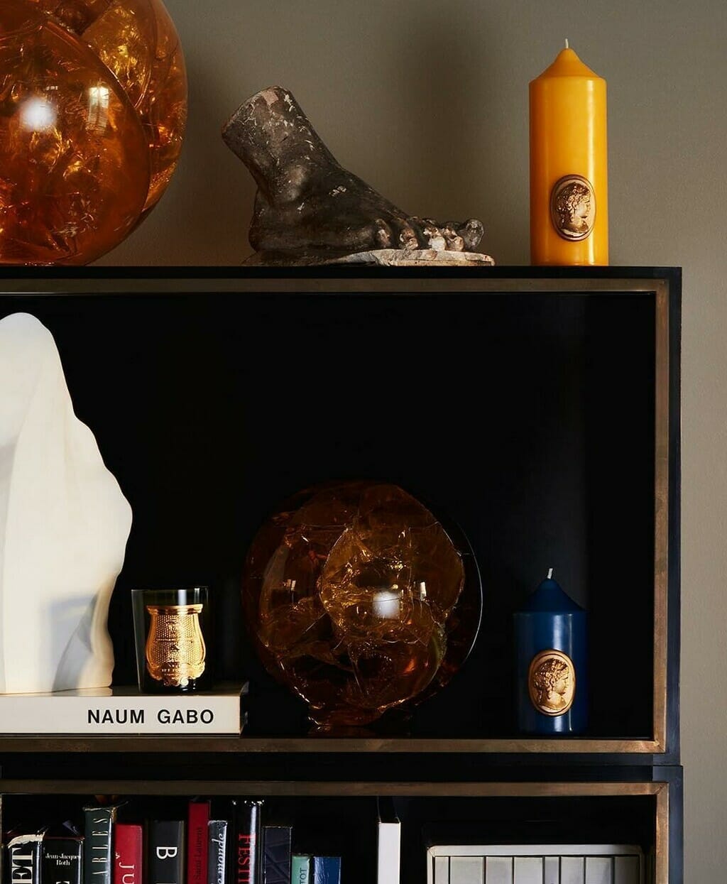 home fragrance line from Cire Trudon displayed on a bookshelf. 
