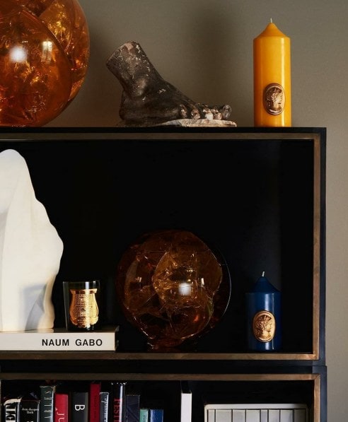 home fragrance line from Cire Trudon displayed on a bookshelf. 