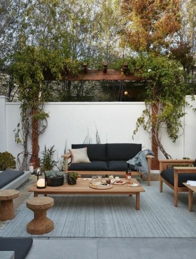 The seating area of a modern outdoor space showcasing an outdoor rug. 