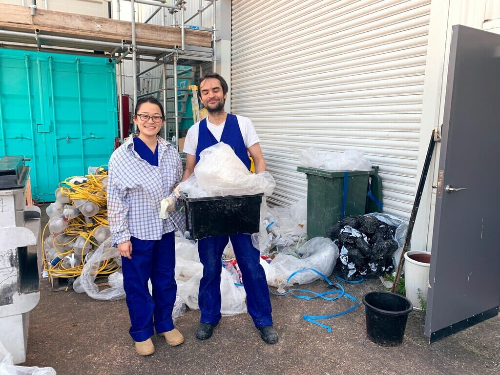 2 people are standing in blue overalls holding rubbish nz healthy home standards