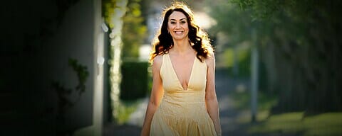 Women walking down the street in yellow dress smiling.
