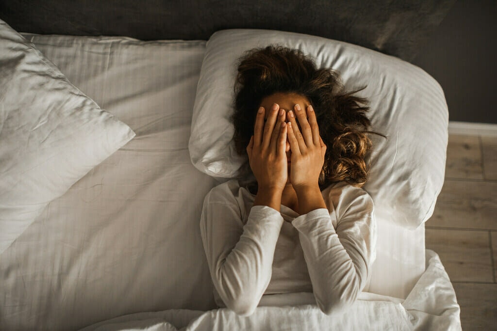 distressed lady in bed. distressed woman trying to find the meaning of dream.