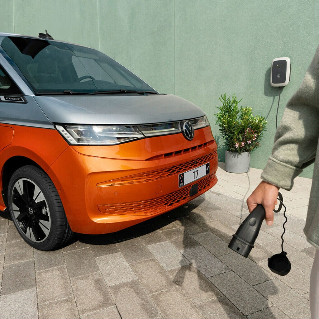 The front design of an orange and silver Volkswagen EV. 