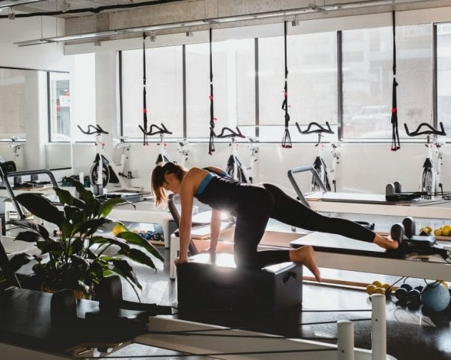 Woman doing pilates at the Reform Fitness gym studio.