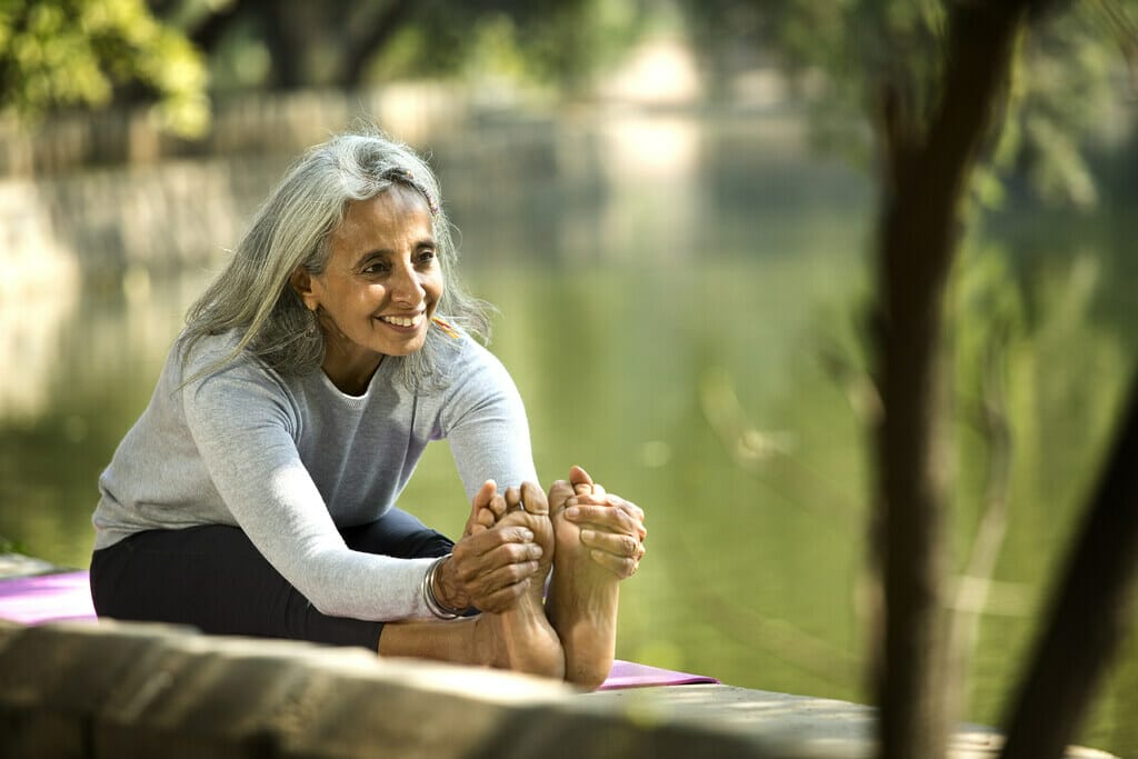 Elderly lady enjoying yoga at an aged-care facility. 