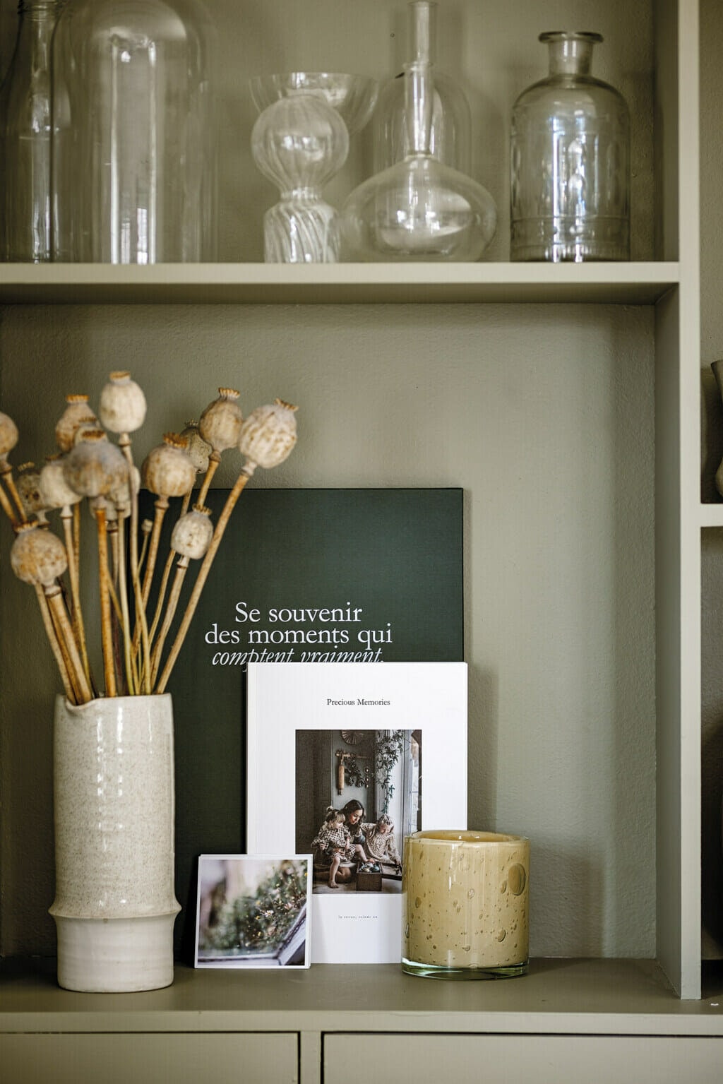 A small nook with decorative flowers, candle and books. 