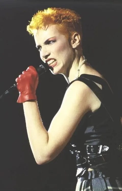 Annie Lennox singing in red gloves