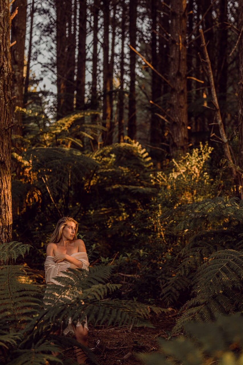 Women standing amongst native New Zealand bush wearing a sheer dress