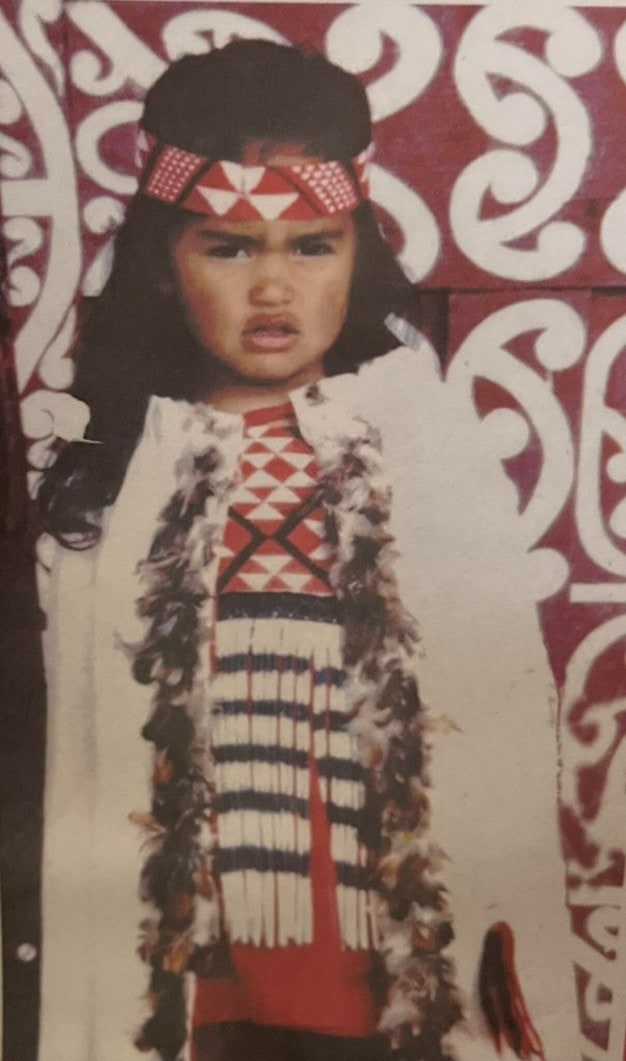 Small child dressed in traditional maori costume