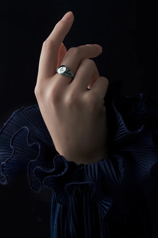 Silver Ring on Hand with Navy Ruffled Sleeves