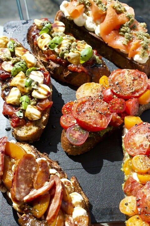 Ciabatta slices with breakfast toppings. Roasted tomatoes, salmon and basil.
