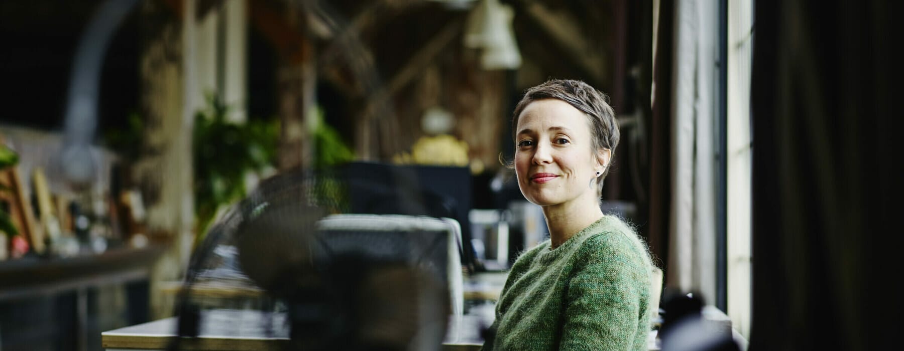 Smiling businesswoman sitting at workstation in design firm